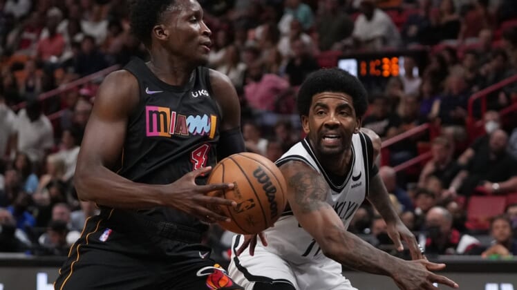 Mar 26, 2022; Miami, Florida, USA; Brooklyn Nets guard Kyrie Irving (11) knocks the ball away from Miami Heat guard Victor Oladipo (4) during the first half at FTX Arena. Mandatory Credit: Jasen Vinlove-USA TODAY Sports