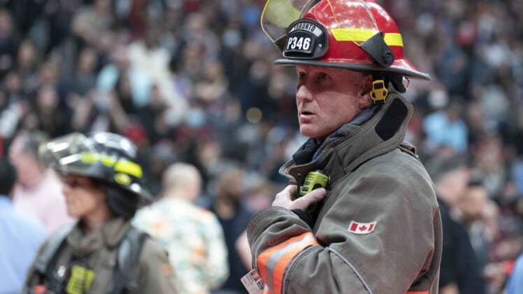 Mar 26, 2022; Toronto, Ontario, CAN; A Toronto Fire Fighter watches as fans begin to exit Scotiabank Arena due to a fire emergency during the second quarter between the Indiana Pacers and Toronto Raptors. Mandatory Credit: Nick Turchiaro-USA TODAY Sports