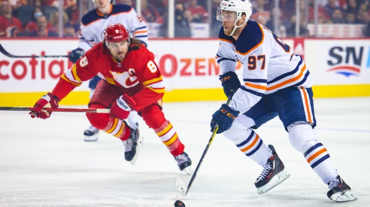 Mar 26, 2022; Calgary, Alberta, CAN; Edmonton Oilers center Connor McDavid (97) controls the puck against the Calgary Flames during the first period at Scotiabank Saddledome. Mandatory Credit: Sergei Belski-USA TODAY Sports