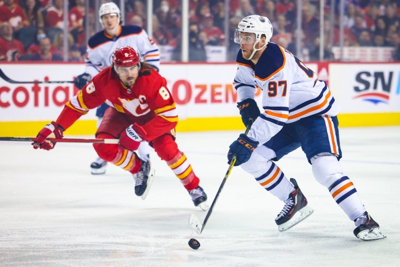Mar 26, 2022; Calgary, Alberta, CAN; Edmonton Oilers center Connor McDavid (97) controls the puck against the Calgary Flames during the first period at Scotiabank Saddledome. Mandatory Credit: Sergei Belski-USA TODAY Sports