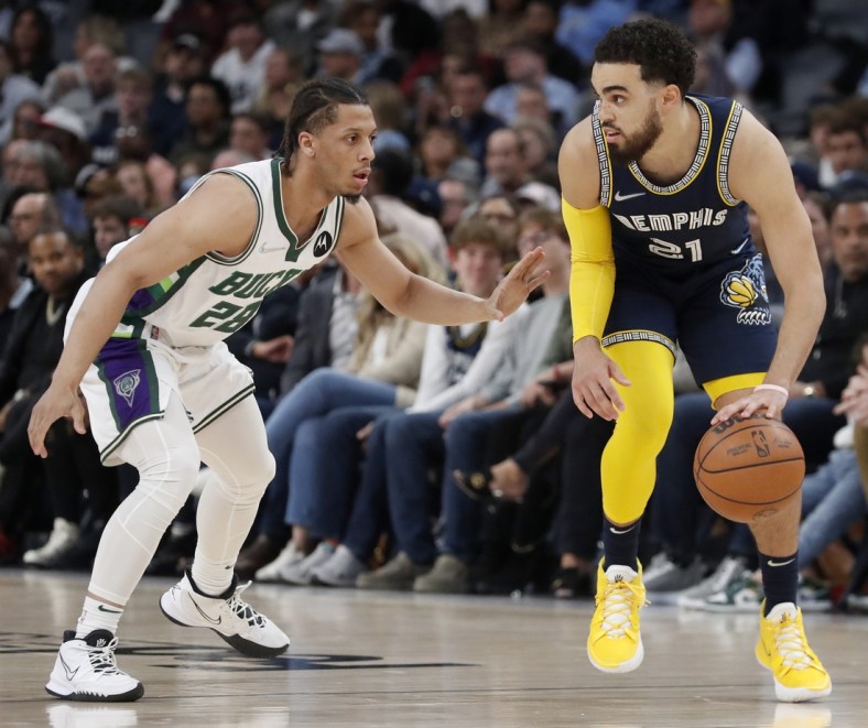Mar 26, 2022; Memphis, Tennessee, USA;  Memphis Grizzlies guard Tyus Jones (21) controls the ball against Milwaukee Bucks guard Lindell Wigginton (28) during the second half at FedExForum. The Grizzlies won 127-102. Mandatory Credit: Christine Tannous-USA TODAY Sports
