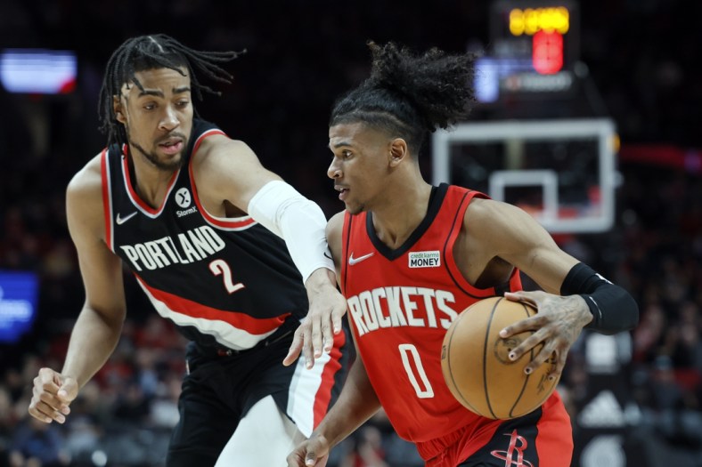 Mar 26, 2022; Portland, Oregon, USA; Houston Rockets shooting guard Jalen Green (0) dribbles the ball while defended by Portland Trail Blazers power forward Trendon Watford (2) during the second half at Moda Center. Mandatory Credit: Soobum Im-USA TODAY Sports