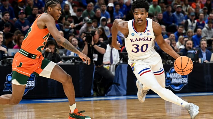 Mar 27, 2022; Chicago, IL, USA; Kansas Jayhawks guard Ochai Agbaji (30) drives past Miami Hurricanes guard Kameron McGusty (23) during the first half in the finals of the Midwest regional of the men's college basketball NCAA Tournament at United Center. Mandatory Credit: Jamie Sabau-USA TODAY Sports