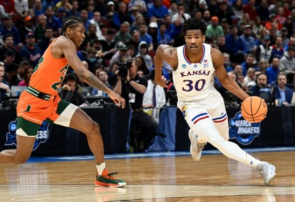 Mar 27, 2022; Chicago, IL, USA; Kansas Jayhawks guard Ochai Agbaji (30) drives past Miami Hurricanes guard Kameron McGusty (23) during the first half in the finals of the Midwest regional of the men's college basketball NCAA Tournament at United Center. Mandatory Credit: Jamie Sabau-USA TODAY Sports