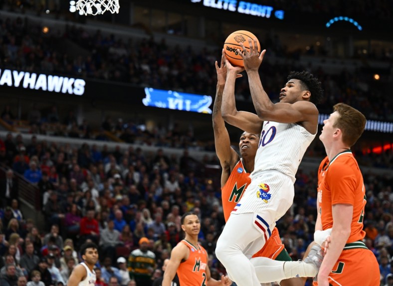 Mar 27, 2022; Chicago, IL, USA; Kansas Jayhawks guard Ochai Agbaji (30) shoots past Miami Hurricanes guard Kameron McGusty (23) during the first half in the finals of the Midwest regional of the men's college basketball NCAA Tournament at United Center. Mandatory Credit: Jamie Sabau-USA TODAY Sports