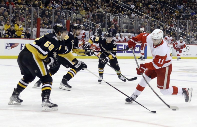 Mar 27, 2022; Pittsburgh, Pennsylvania, USA;  Detroit Red Wings right wing Filip Zadina (11) shoots the puck against the Pittsburgh Penguins during the first period at PPG Paints Arena. Mandatory Credit: Charles LeClaire-USA TODAY Sports