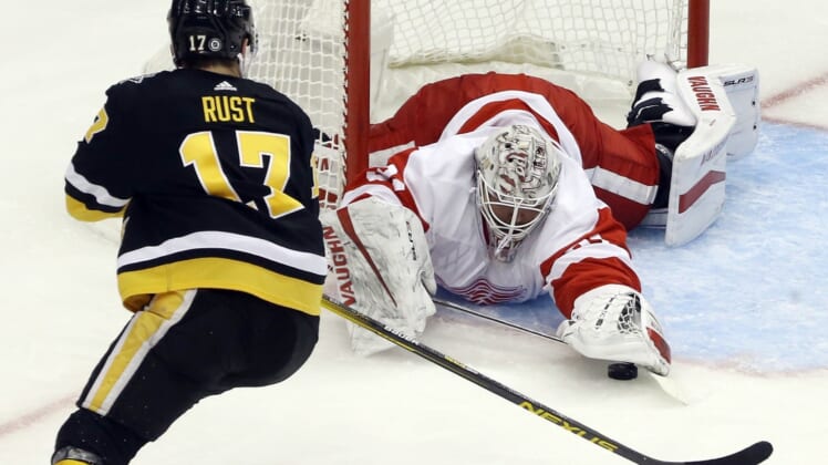 Mar 27, 2022; Pittsburgh, Pennsylvania, USA; Detroit Red Wings goaltender Calvin Pickard (right) covers the puck as Pittsburgh Penguins right wing Bryan Rust (17) looks for a rebound during the second period at PPG Paints Arena. Mandatory Credit: Charles LeClaire-USA TODAY Sports