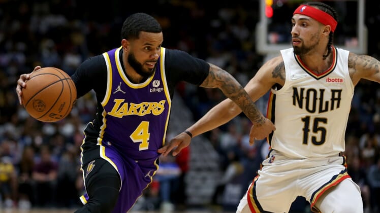 Mar 27, 2022; New Orleans, Louisiana, USA; Los Angeles Lakers guard D.J. Augustin (4) drives on New Orleans Pelicans guard Jose Alvarado (15) in the second quarter at the Smoothie King Center. Mandatory Credit: Chuck Cook-USA TODAY Sports