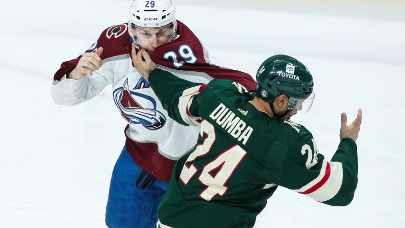 Mar 27, 2022; Saint Paul, Minnesota, USA; Colorado Avalanche center Nathan MacKinnon (29) and Minnesota Wild defenseman Matt Dumba (24) fight in the third period at Xcel Energy Center. Mandatory Credit: David Berding-USA TODAY Sports