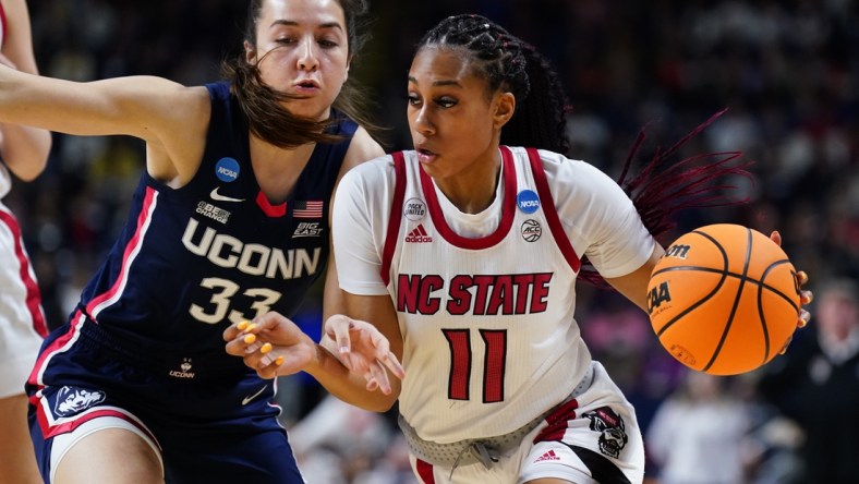 Mar 28, 2022; Bridgeport, CT, USA; NC State Wolfpack forward Jakia Brown-Turner (11) drives the ball against UConn Huskies guard Caroline Ducharme (33) during the first half in the Bridgeport regional finals of the women's college basketball NCAA Tournament at Webster Bank Arena. Mandatory Credit: David Butler II-USA TODAY Sports