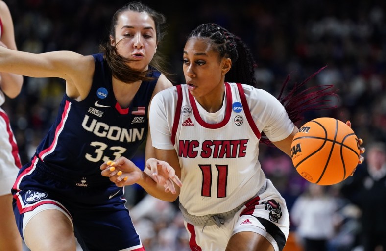 Mar 28, 2022; Bridgeport, CT, USA; NC State Wolfpack forward Jakia Brown-Turner (11) drives the ball against UConn Huskies guard Caroline Ducharme (33) during the first half in the Bridgeport regional finals of the women's college basketball NCAA Tournament at Webster Bank Arena. Mandatory Credit: David Butler II-USA TODAY Sports