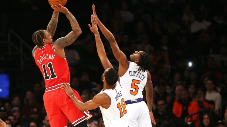 Mar 28, 2022; New York, New York, USA: Chicago Bulls forward DeMar DeRozan (11) shoots against New York Knicks guard Alec Burks (18) and guard Immanuel Quickley (5) during the first half at Madison Square Garden. Mandatory Credit: Andy Marlin-USA TODAY Sports