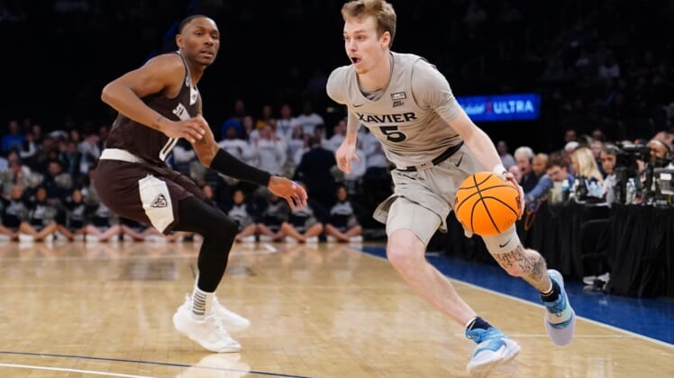 Mar 29, 2022; New York, New York, USA; Xavier Musketeers guard Adam Kunkel (5) dribbles the ball pst St. Bonaventure Bonnies guard Kyle Lofton (0) defending  during the NIT college basketball semifinals at Madison Square Garden. Mandatory Credit: Gregory Fisher-USA TODAY Sports