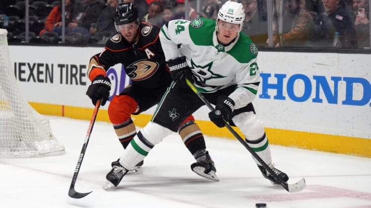Mar 29, 2022; Anaheim, California, USA; Dallas Stars center Roope Hintz (24) and Anaheim Ducks defenseman Cam Fowler (4) battle for the puck in the third period at Honda Center. Mandatory Credit: Kirby Lee-USA TODAY Sports