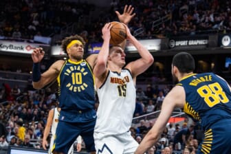Mar 30, 2022; Indianapolis, Indiana, USA; Denver Nuggets center Nikola Jokic (15) shoots the ball while Indiana Pacers forward Justin Anderson (10) defends in the first half at Gainbridge Fieldhouse. Mandatory Credit: Trevor Ruszkowski-USA TODAY Sports