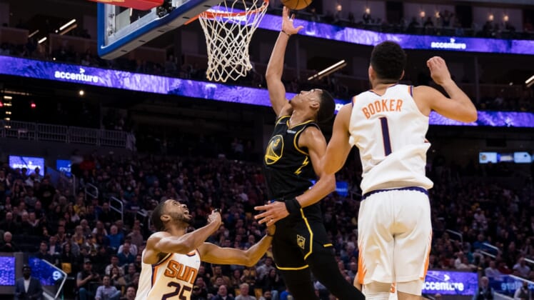 Mar 30, 2022; San Francisco, California, USA; Phoenix Suns forward Mikal Bridges (25) and guard Devin Booker (1) defend against Golden State Warriors guard Jordan Poole (3) during the first half at Chase Center. Mandatory Credit: John Hefti-USA TODAY Sports