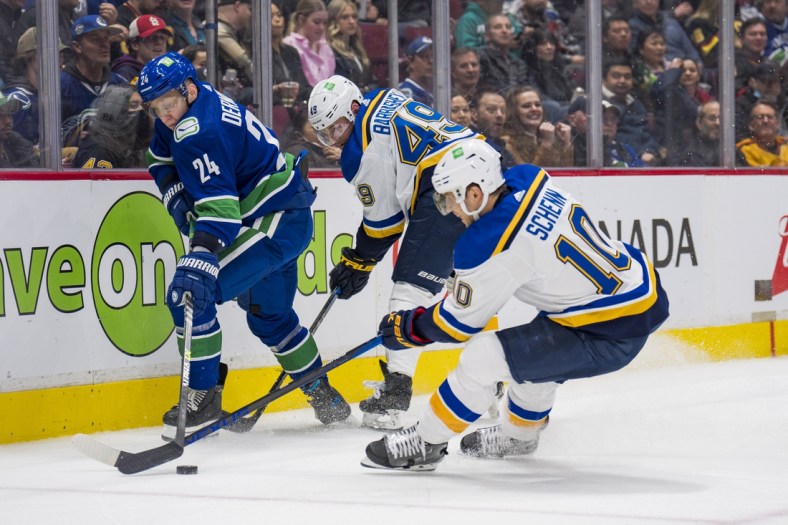 Mar 30, 2022; Vancouver, British Columbia, CAN; St. Louis Blues forward Ivan Barbashev (49) and forward Brayden Schenn (10) battle with Vancouver Canucks defenseman Travis Dermott (24) in the second period at Rogers Arena. Mandatory Credit: Bob Frid-USA TODAY Sports