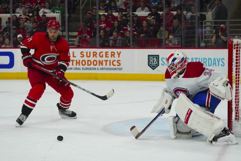 Mar 31, 2022; Raleigh, North Carolina, USA;  Montreal Canadiens goaltender Jake Allen (34) and Carolina Hurricanes right wing Nino Niederreiter (21) watch the puck during the first period at PNC Arena. Mandatory Credit: James Guillory-USA TODAY Sports