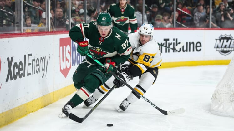 Mar 31, 2022; Saint Paul, Minnesota, USA; Minnesota Wild left wing Kirill Kaprizov (97) and Pittsburgh Penguins center Sidney Crosby (87) compete for the puck in the first period at Xcel Energy Center. Mandatory Credit: David Berding-USA TODAY Sports