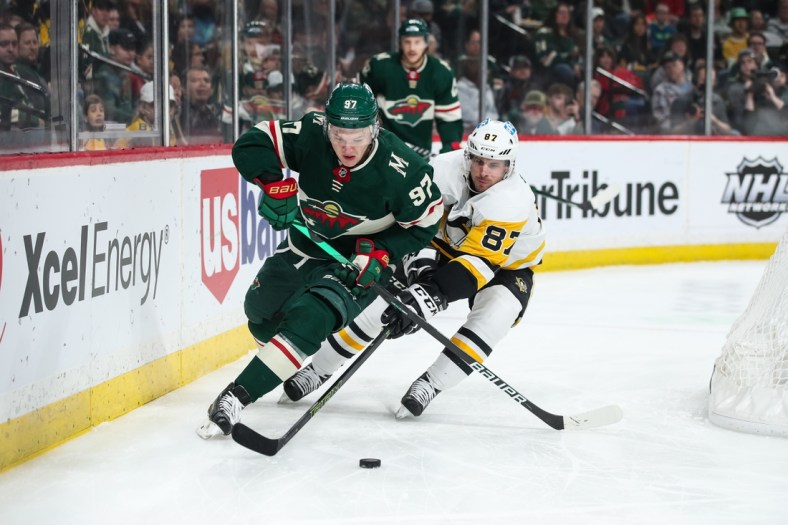 Mar 31, 2022; Saint Paul, Minnesota, USA; Minnesota Wild left wing Kirill Kaprizov (97) and Pittsburgh Penguins center Sidney Crosby (87) compete for the puck in the first period at Xcel Energy Center. Mandatory Credit: David Berding-USA TODAY Sports