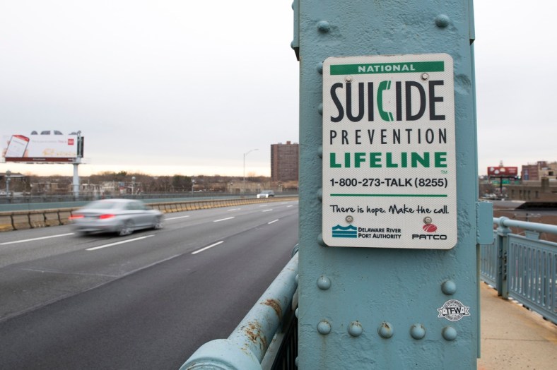 A sign for the National Suicide Prevention Hotline on the Camden side of the Benjamin Franklin Bridge.