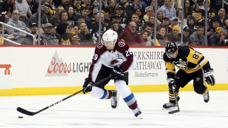 Oct 16, 2019; Pittsburgh, PA, USA; Colorado Avalanche center Nathan MacKinnon (29) breaks up ice with the puck ahead of Pittsburgh Penguins center Sidney Crosby (87)during the third period at PPG PAINTS Arena. Pittsburgh won 3-2 in overtime. Mandatory Credit: Charles LeClaire-USA TODAY Sports