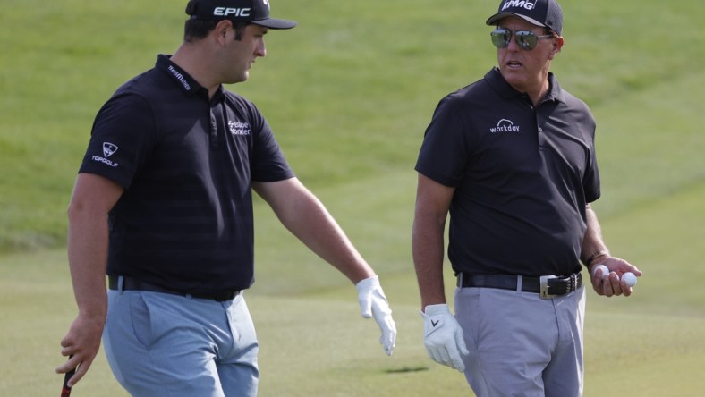 May 17, 2021; Kiawah Island, South Carolina, USA; Jon Rahm (L) and Phil Mickelson (R) talk on the sixteenth green during a practice round for the PGA Championship golf tournament at Ocean Course at Kiawah Island Resort. Mandatory Credit: Geoff Burke-USA TODAY Sports