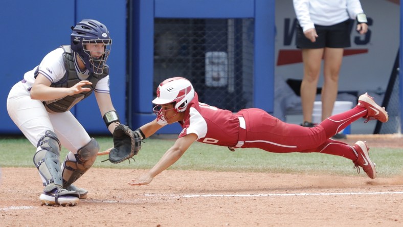 Jun 6, 2021; Oklahoma City, Oklahoma, USA;  Oklahoma s Rylie Boone (0) slides in at home past James Madison catcher Lauren Bernett (22) to score a run in the sixth inning during a Women s College World Series semi finals game at USA Softball Hall of Fame Stadium. Oklahoma won 6-3. Mandatory Credit: Alonzo Adams-USA TODAY Sports