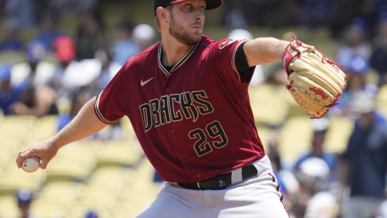 Jul 11, 2021; Los Angeles, California, USA; Arizona Diamondbacks starting pitcher Merrill Kelly (29) delivers a pitch during the first inning against the Los Angeles Dodgers at Dodger Stadium. Mandatory Credit: Robert Hanashiro-USA TODAY Sports