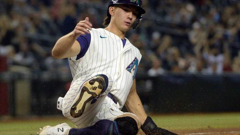 Sep 3, 2021; Phoenix, Arizona, USA; Arizona Diamondbacks left fielder Stuart Fairchild (63) slides at home plate and scores a run against the Seattle Mariners during the seventh inning at Chase Field. Mandatory Credit: Joe Camporeale-USA TODAY Sports