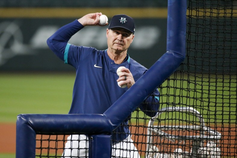 Sep 29, 2021; Seattle, Washington, USA; Seattle Mariners manager Scott Servais (9) throws batting practice to his players before a game against the Oakland Athletics at T-Mobile Park. Mandatory Credit: Joe Nicholson-USA TODAY Sports