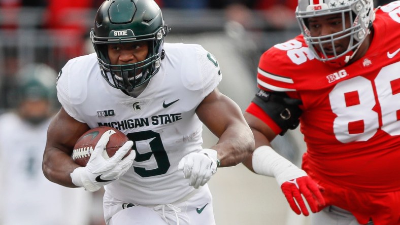 Michigan State Spartans running back Kenneth Walker III (9) runs past Ohio State Buckeyes defensive tackle Jerron Cage (86) during the first quarter of the NCAA football game at Ohio Stadium in Columbus on Saturday, Nov. 20, 2021.

Michigan State Spartans At Ohio State Buckeyes Football