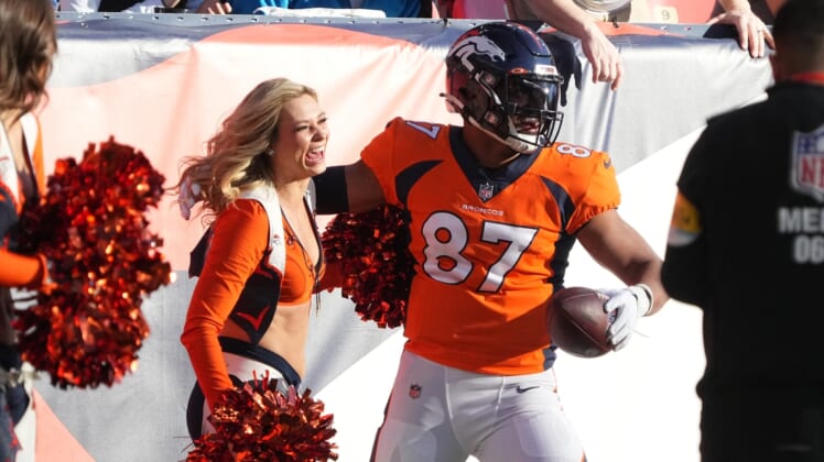 Dec 12, 2021; Denver, Colorado, USA; Denver Broncos tight end Noah Fant (87) reacts after running into a cheerleader following a reception prepares in the first quarter against the Detroit Lions at Empower Field at Mile High. Mandatory Credit: Ron Chenoy-USA TODAY Sports
