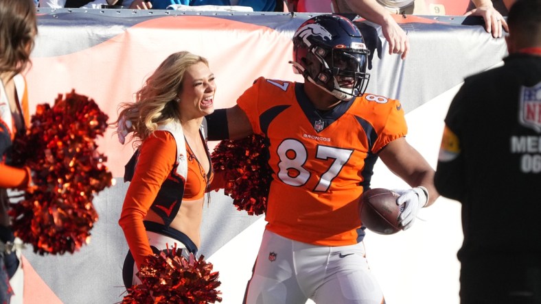 Dec 12, 2021; Denver, Colorado, USA; Denver Broncos tight end Noah Fant (87) reacts after running into a cheerleader following a reception prepares in the first quarter against the Detroit Lions at Empower Field at Mile High. Mandatory Credit: Ron Chenoy-USA TODAY Sports