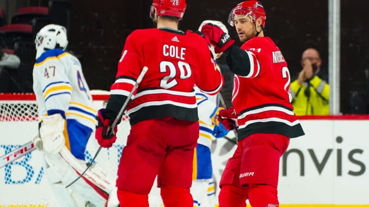 Dec 4, 2021; Raleigh, North Carolina, USA;  Carolina Hurricanes defenseman Ian Cole (28) is congratulated by  right wing Nino Niederreiter (21) after his goal against the Buffalo Sabres during the second period at PNC Arena. Mandatory Credit: James Guillory-USA TODAY Sports