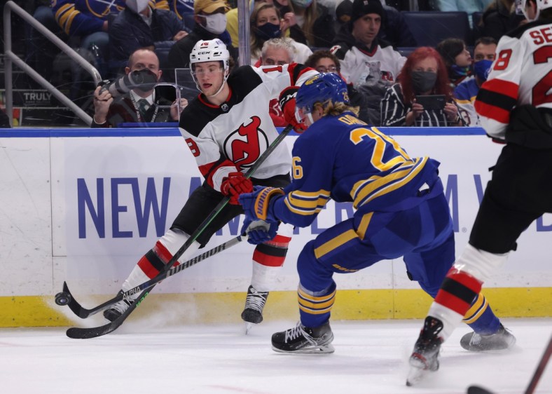 Dec 29, 2021; Buffalo, New York, USA; Buffalo Sabres defenseman Rasmus Dahlin (26) knocks down a pass by New Jersey Devils center Dawson Mercer (18) during the first period at KeyBank Center. Mandatory Credit: Timothy T. Ludwig-USA TODAY Sports