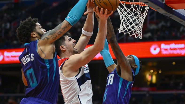 Jan 3, 2022; Washington, District of Columbia, USA; Charlotte Hornets forward Miles Bridges (0) blocks the shot of Washington Wizards forward Deni Avdija (9) during the second half at Capital One Arena. Mandatory Credit: Brad Mills-USA TODAY Sports