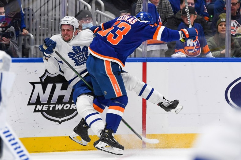 Jan 22, 2022; Elmont, New York, USA;  New York Islanders center Casey Cizikas (53) checks Toronto Maple Leafs defenseman Carl Dahlstrom (48) into the boards during the second period at UBS Arena. Mandatory Credit: Dennis Schneidler-USA TODAY Sports