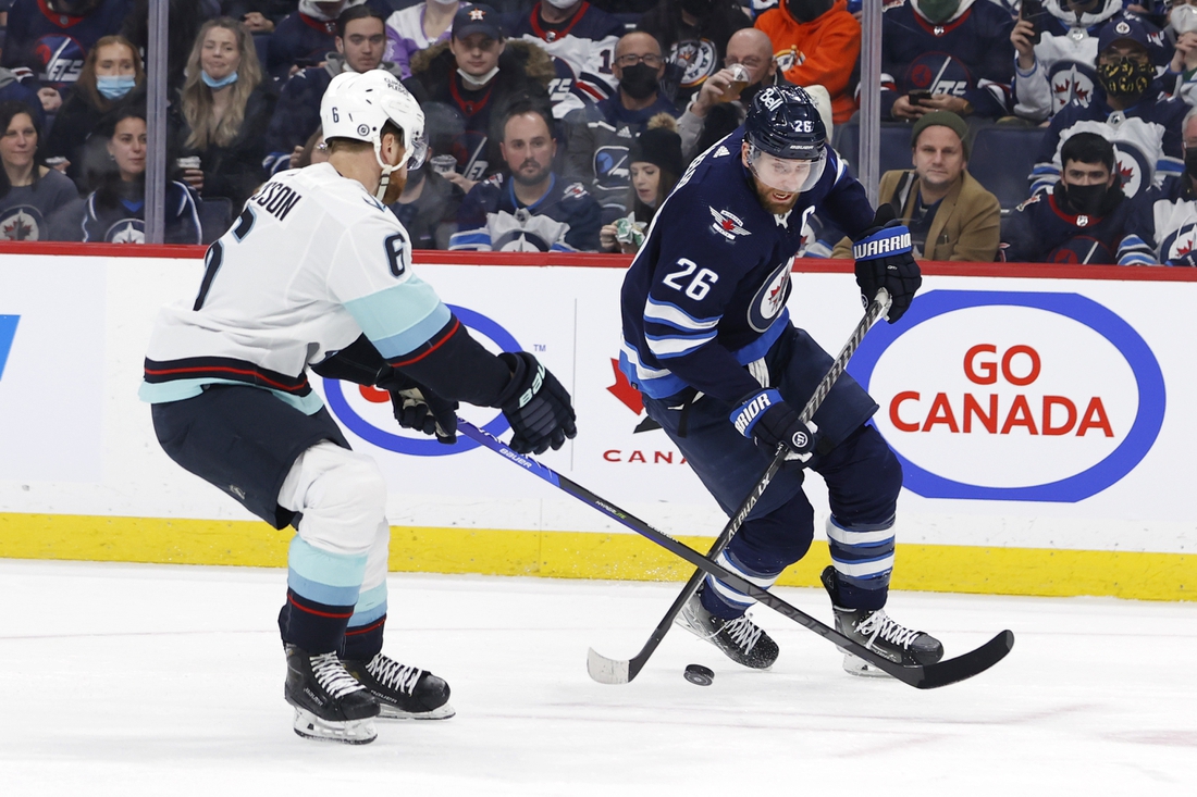 Feb 17, 2022; Winnipeg, Manitoba, CAN; Seattle Kraken defenseman Adam Larsson (6) checks Winnipeg Jets right wing Blake Wheeler (26) in the second period at Canada Life Centre. Mandatory Credit: James Carey Lauder-USA TODAY Sports