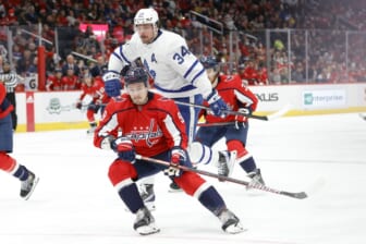 Feb 28, 2022; Washington, District of Columbia, USA; Toronto Maple Leafs center Auston Matthews (34) leaps around the check of Washington Capitals defenseman Dmitry Orlov (9) while chasing the puck in the second period at Capital One Arena. Mandatory Credit: Geoff Burke-USA TODAY Sports