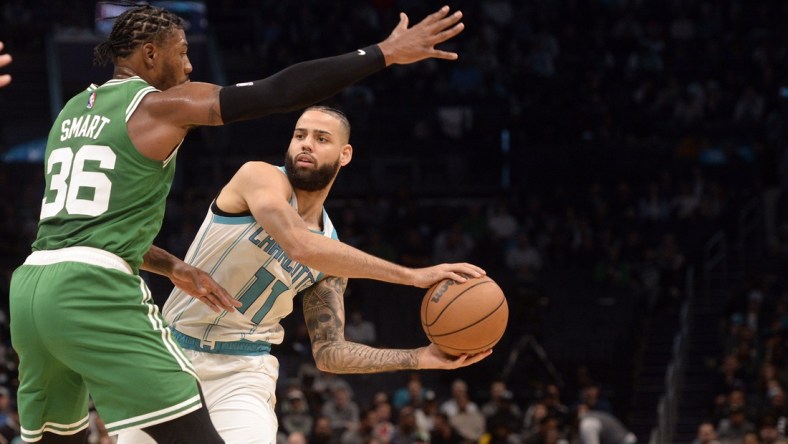 Mar 9, 2022; Charlotte, North Carolina, USA;  Charlotte Hornets guard forward Cody Martin (11) looks to pass as he is defended by Boston Celtics guard Marcus Smart (36)  during the first half at the Spectrum Center. Mandatory Credit: Sam Sharpe-USA TODAY Sports