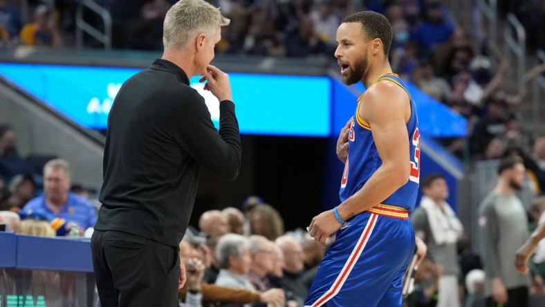 Mar 12, 2022; San Francisco, California, USA; Golden State Warriors guard Stephen Curry (30) talks to head coach Steve Kerr during the third quarter against the Milwaukee Bucks at Chase Center. Mandatory Credit: Darren Yamashita-USA TODAY Sports