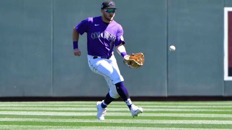 Mar 24, 2022; Salt River Pima-Maricopa, Arizona, USA;  Colorado Rockies center fielder Garrett Hampson (1) fields a ground ball in the second inning against the Los Angeles Dodgers during spring training at Salt River Fields at Talking Stick. Mandatory Credit: Matt Kartozian-USA TODAY Sports