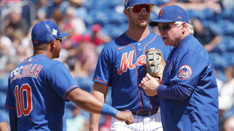 Mar 26, 2022; Port St. Lucie, Florida, USA;  New York Mets third baseman Eduardo Escobar (10) talks to Mets manager Buck Showalter, right, as first baseman Pete Alonso, top, looks on during the sixth inning against the Washington Nationals at Clover Park. Mandatory Credit: Reinhold Matay-USA TODAY Sports