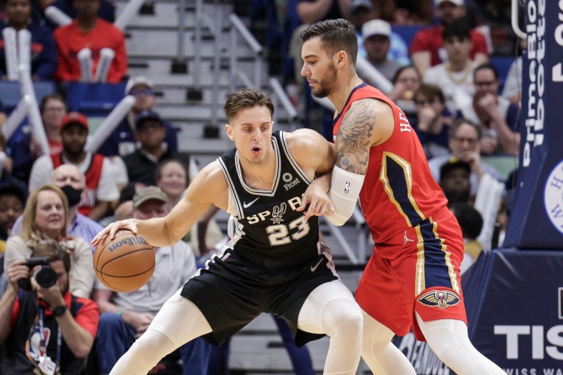 Mar 26, 2022; New Orleans, Louisiana, USA;  San Antonio Spurs forward Zach Collins (23) controls the ball against New Orleans Pelicans center Willy Hernangomez (9) during the second half at the New Orleans Pelicans at the Smoothie King Center. Mandatory Credit: Stephen Lew-USA TODAY Sports