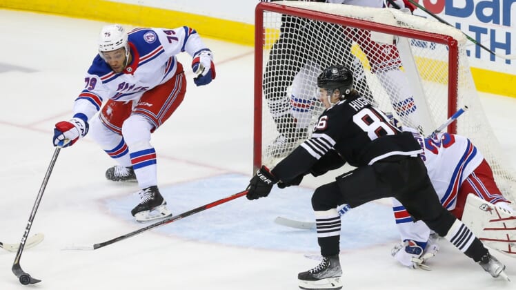 Mar 22, 2022; Newark, New Jersey, USA; New York Rangers defenseman K'Andre Miller (79) pokes the puck away from New Jersey Devils center Jack Hughes (86) during the first period at Prudential Center. Mandatory Credit: Tom Horak-USA TODAY Sports