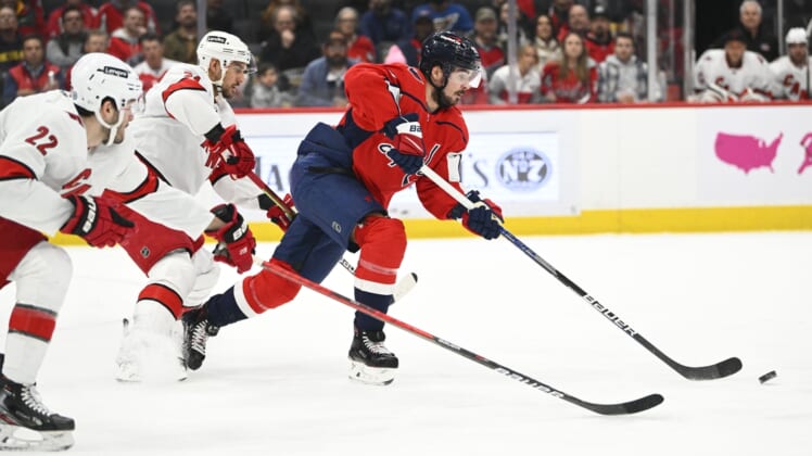 Mar 28, 2022; Washington, District of Columbia, USA; Washington Capitals left wing Marcus Johansson (90) carries the puck past Carolina Hurricanes defenseman Brett Pesce (22) during the first period at Capital One Arena. Mandatory Credit: Brad Mills-USA TODAY Sports