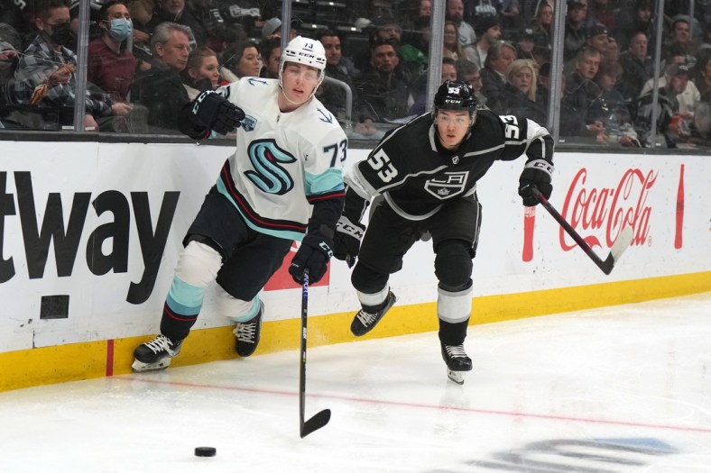 Mar 28, 2022; Los Angeles, California, USA; Seattle Kraken right wing Kole Lind (73) and LA Kings defenseman Jordan Spence (53) battle for the puck at Crypto.com Arena. Mandatory Credit: Kirby Lee-USA TODAY Sports