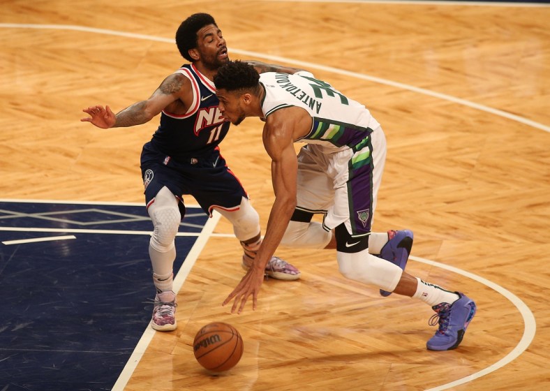 Mar 31, 2022; Brooklyn, New York, USA; Milwaukee Bucks forward Giannis Antetokounmpo (34) dribbles the ball against Brooklyn Nets guard Kyrie Irving (11) during the first half at Barclays Center. Mandatory Credit: Andy Marlin-USA TODAY Sports