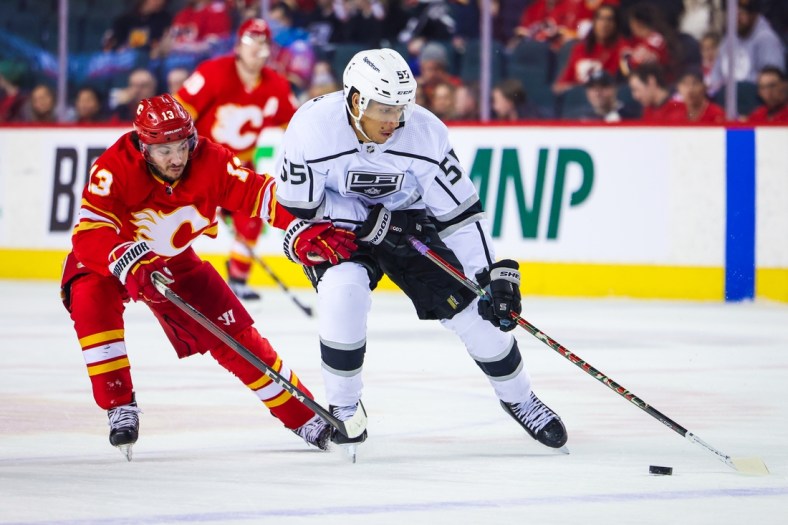 Mar 31, 2022; Calgary, Alberta, CAN; Los Angeles Kings center Quinton Byfield (55) and Calgary Flames left wing Johnny Gaudreau (13) battle for the puck during the second period at Scotiabank Saddledome. Mandatory Credit: Sergei Belski-USA TODAY Sports